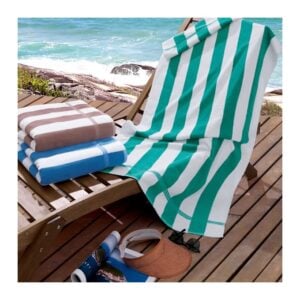 Toalhas de praia listradas personalizadas nas cores bege, azul e verde sobre espreguicadeira