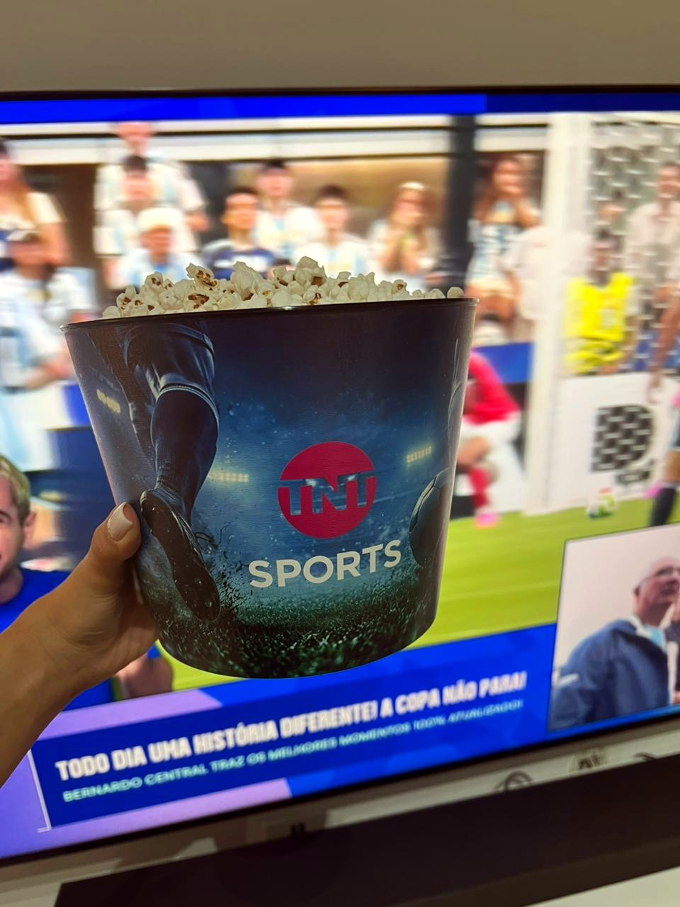 Balde de pipoca TNT Sports em frente à TV com o jogo